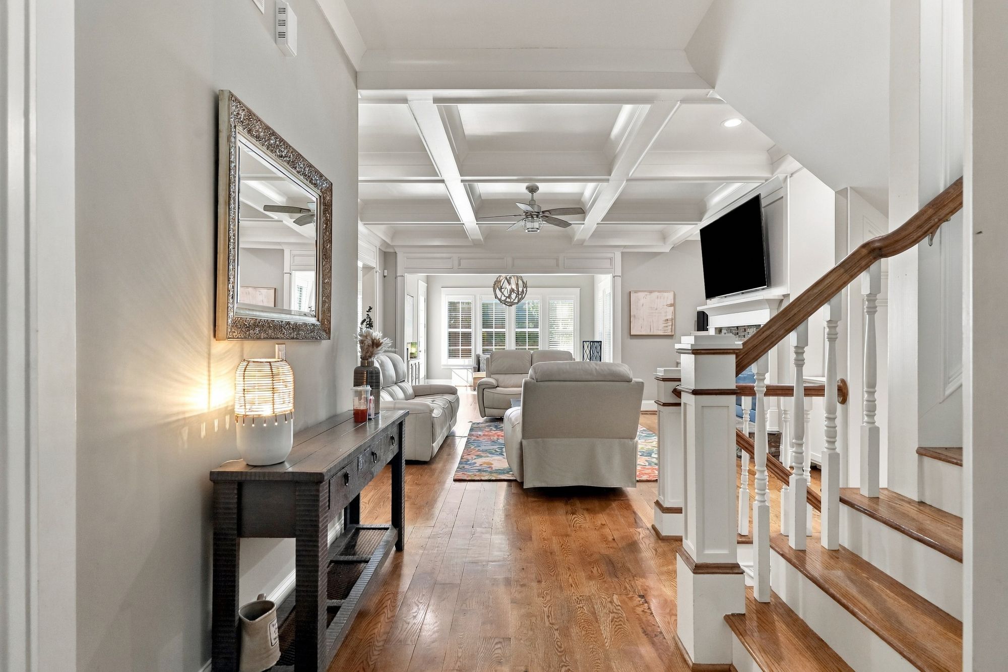 Two-story foyer with classic millwork opening to the coffered family room