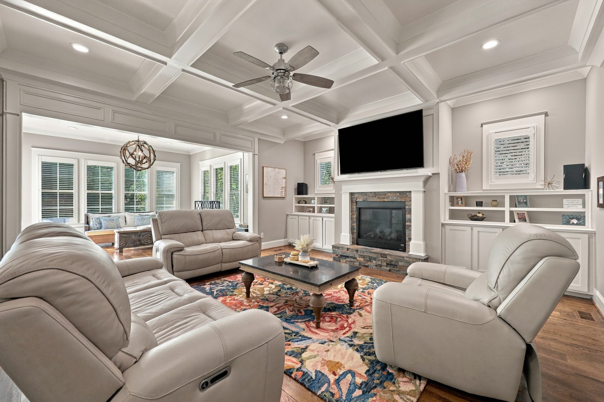 Family room with coffered ceiling, stone fireplace and custom built-ins